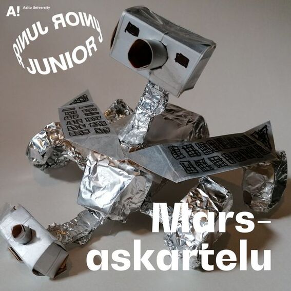 Mars-mönkijän malli, tehty alumiinifoliosta ja pahvista, tekstillä 'Mars-askartelu' ja Aalto-yliopisto Juniorin logolla.