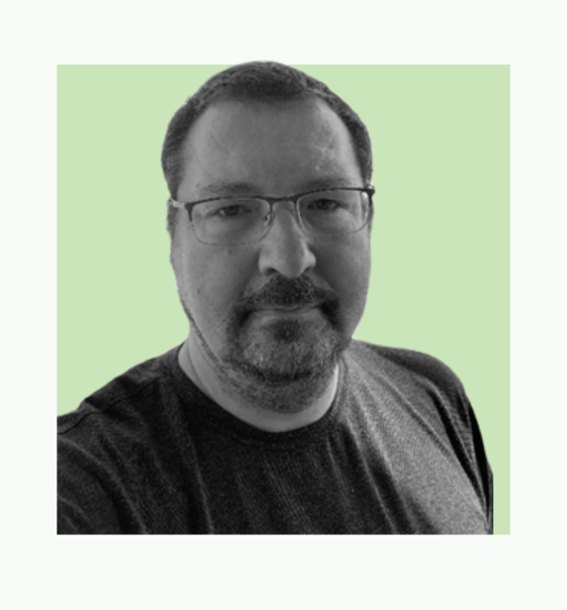 Portrait of a person in a dark T-shirt, face blurred, against a light green background