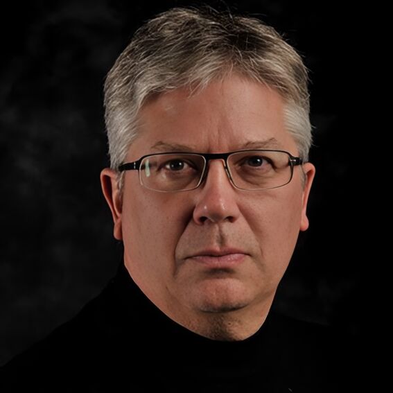 Portrait of a person with grey hair in a black top, face blurred, against a dark background