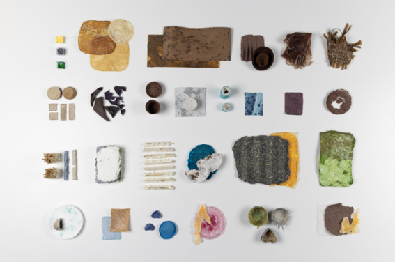 Assorted flat and textured material samples in varied shapes and colours arranged in a grid on a white surface