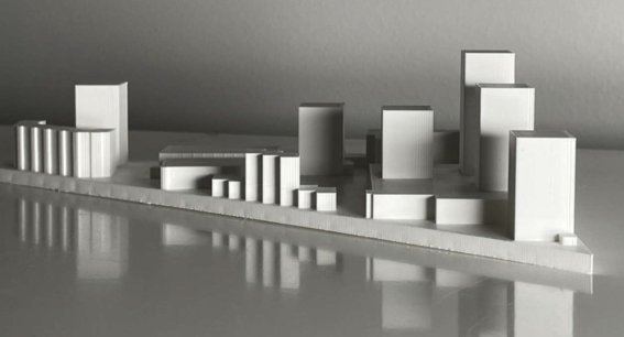 A white architectural model of a city block with various high-rise and low-rise buildings on a reflective surface.