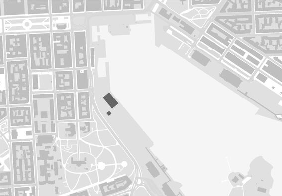 A grayscale map showing a city layout with buildings, streets, and a large open area near the waterfront.