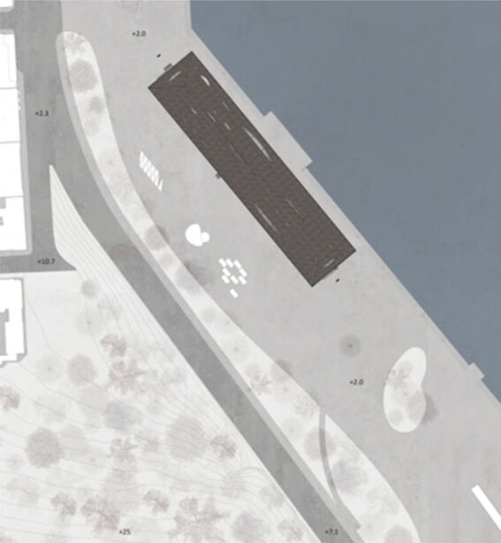 Aerial view of a waterfront area with a rectangular building, pathways, and scattered trees.