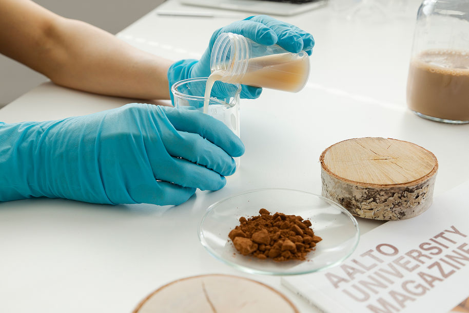 Text: Narrative style photo with a person and action.  (Photo: POCS team/Tiina Puputti & Valeria Azovskaya, materials samples provided by Aalto Materials Platform. 