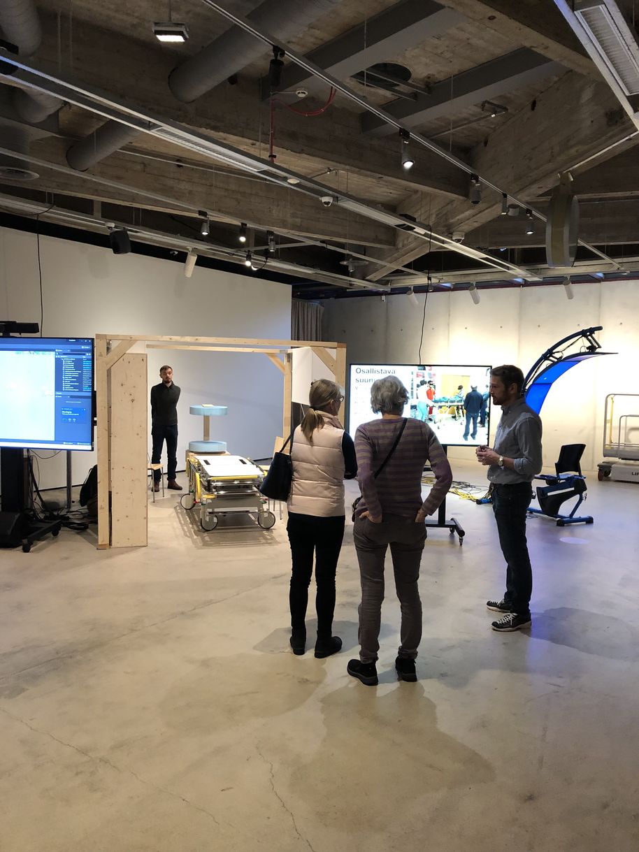 team member talks to visitors about AMRI at the EMMA museum, next to the Mobile Stroke Unit prototype. 