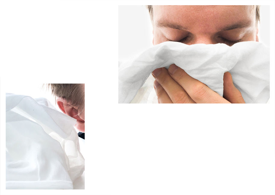A person listening to a white textile and smelling it