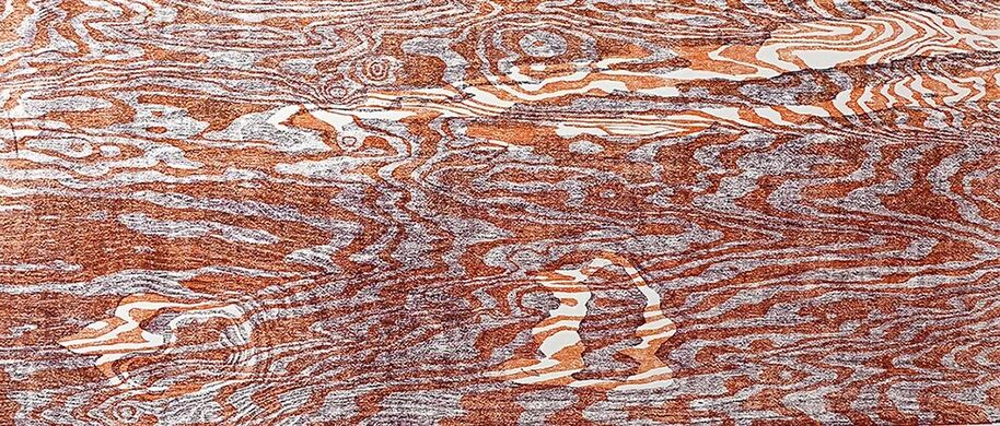 A close-up of a wooden surface with intricate, swirling grain patterns in shades of brown and grey.