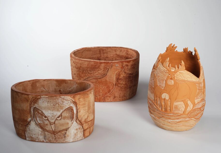 Three carved wooden bowls with animal designs: an owl, a bird, and deer. The background is white.