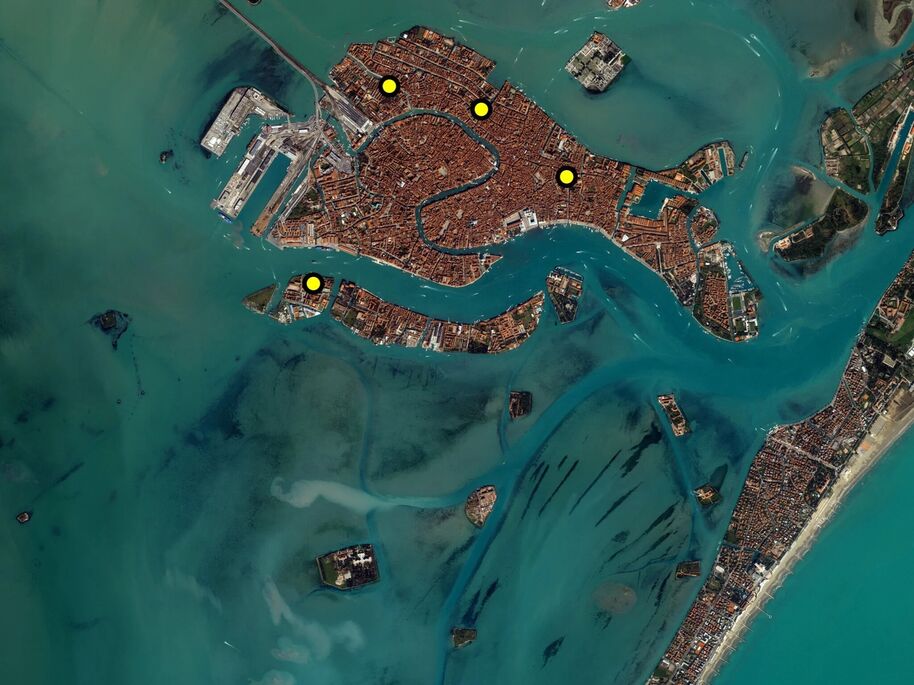 Aerial view of Venice, Italy, surrounded by water. Yellow dots mark locations within the city.