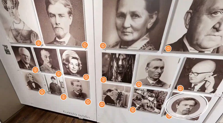 Museon seinäesillepano, jossa useita sumentuja vanhoja muotokuvia ja oransseja infokuvakkeita.