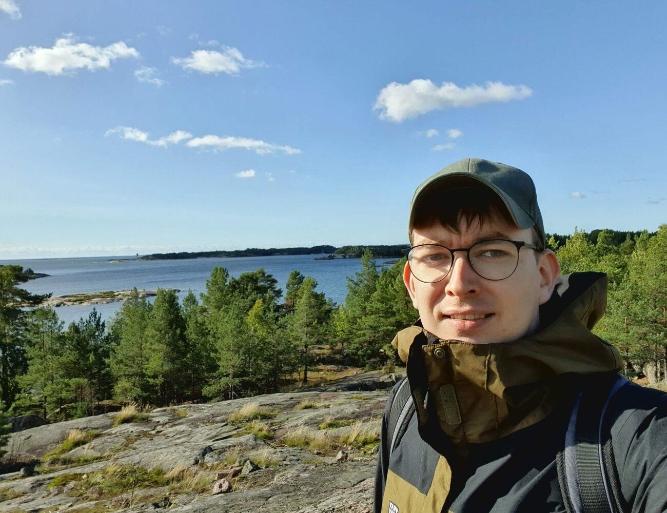 Julius on a cliff near a forrest looking into the camera