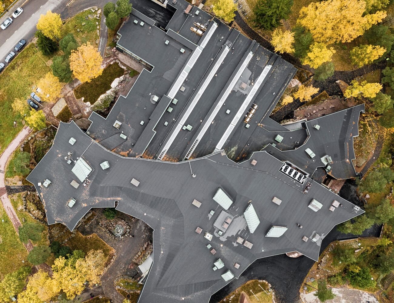 Dipoli from above in the autumn, trees with yellow leaves surround Dipoli on a sunny day