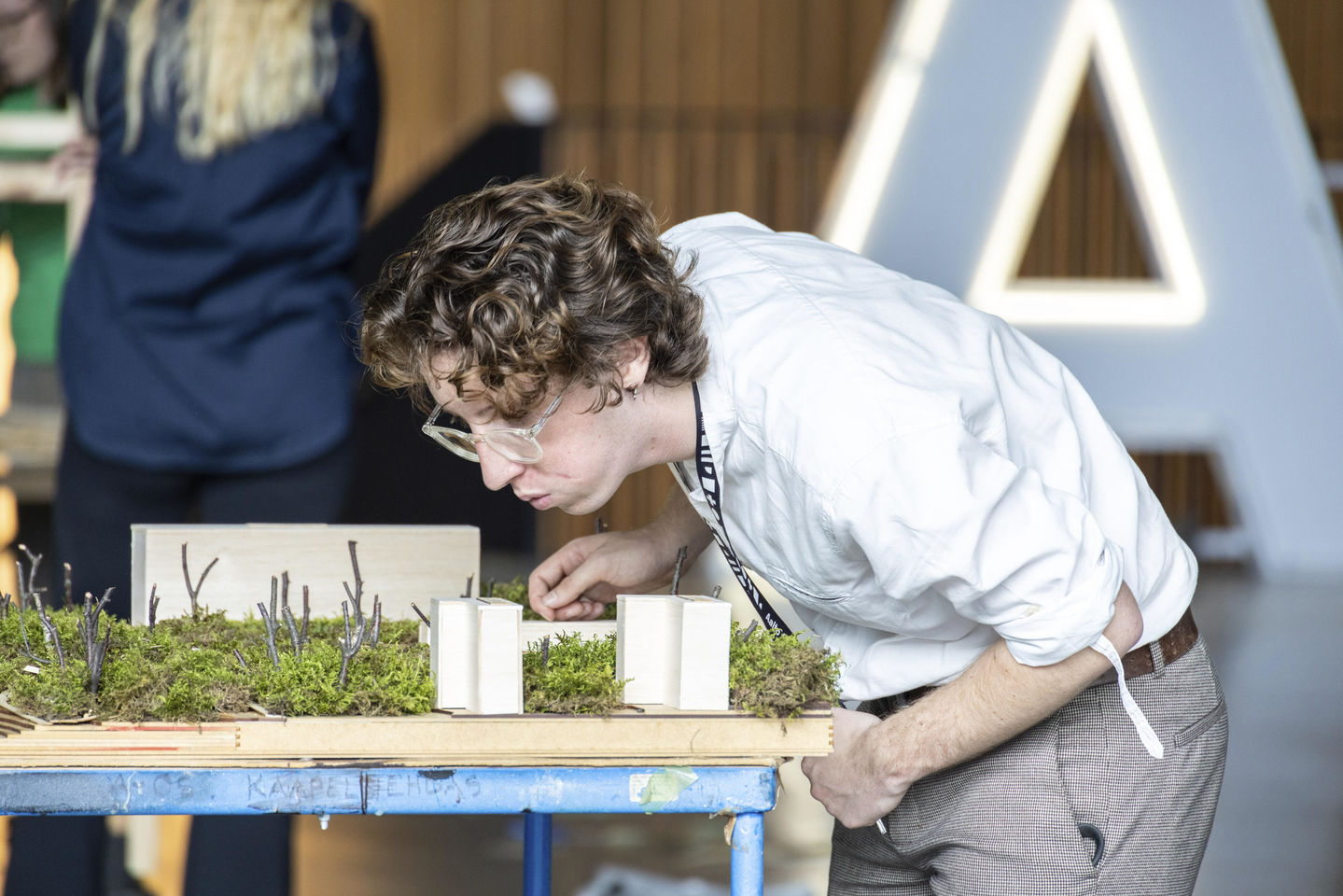 Opiskelija tarkastaa pienoismalliaan