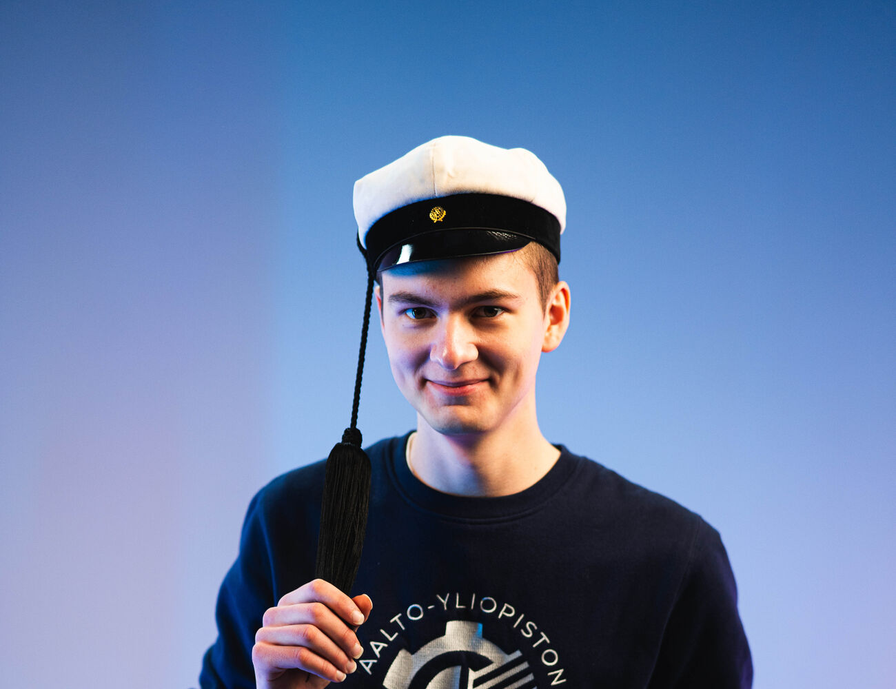 Leevi Oikarinen teekkarilakki päässä studiossa.