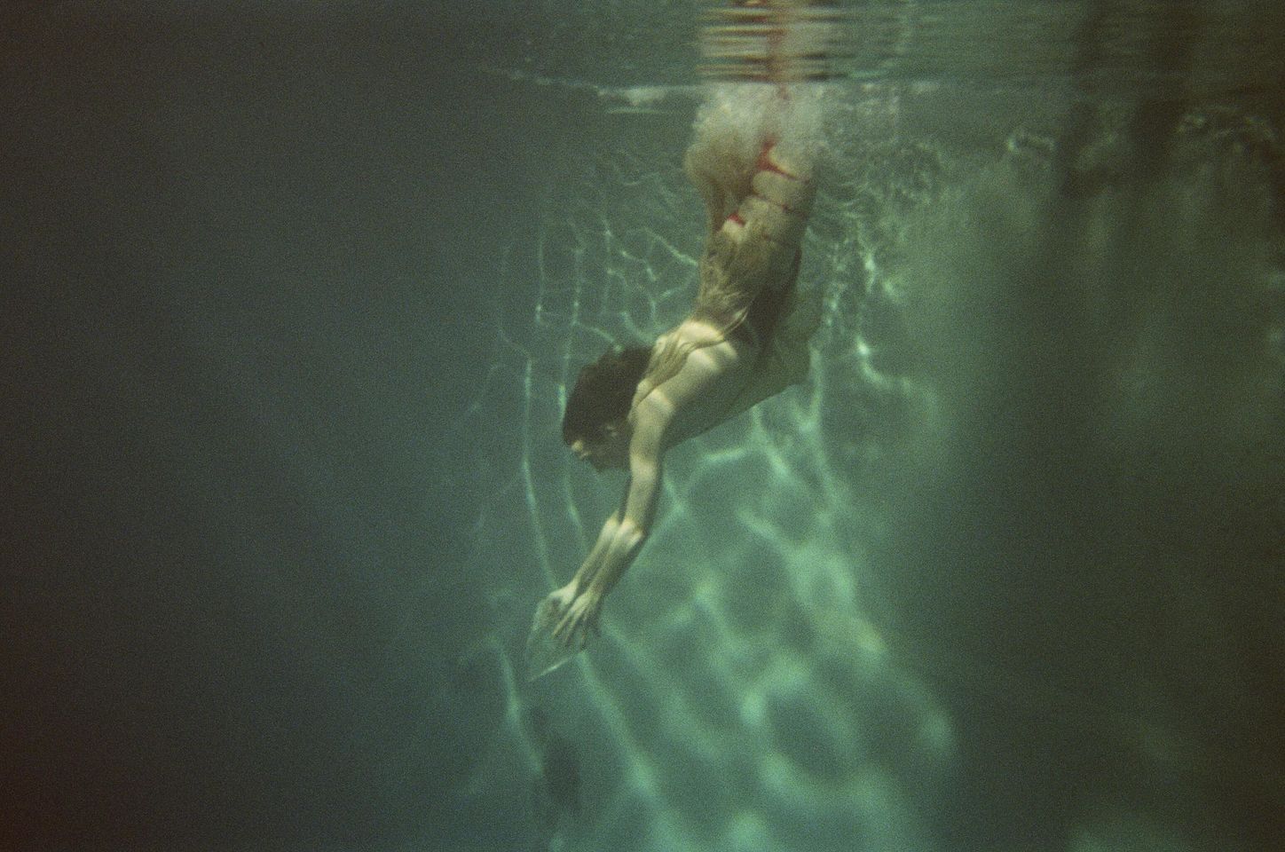 Henkilö sukeltaa veteen.