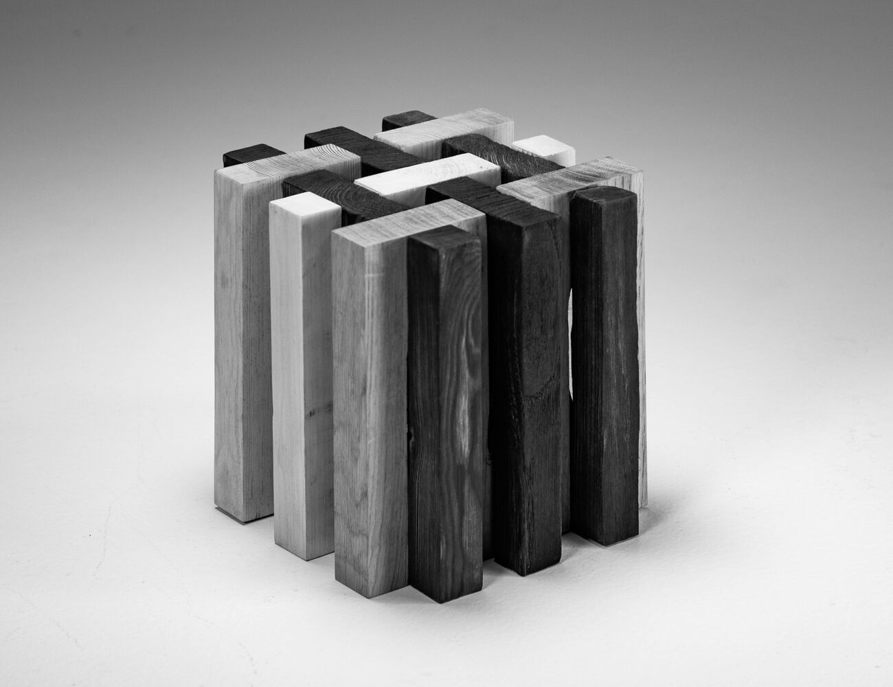 cube consisting of interlocking layers, of three different species; half of which have been charred.