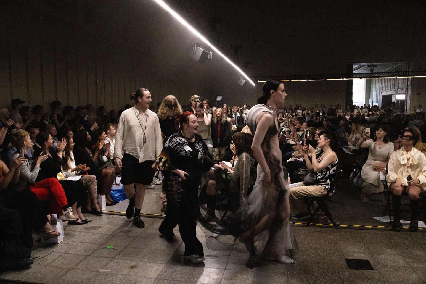 Models and fashion designers walking on the catwalk