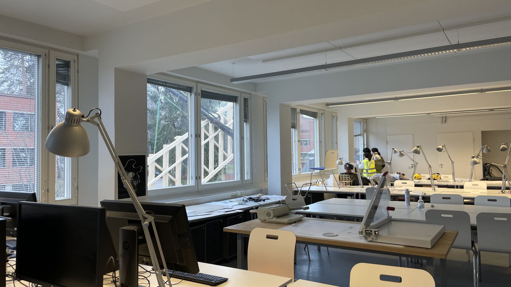 Students watching through a window as the truss is being lifted