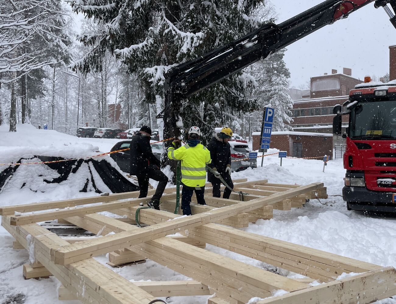 Truss being attached to the crane by students and crane driver