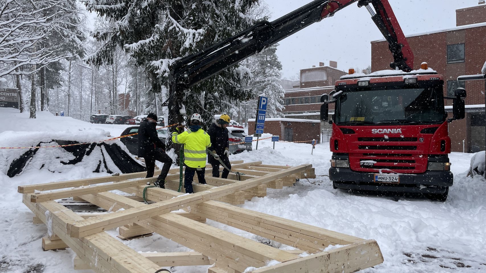 Truss being attached to the crane by students and crane driver