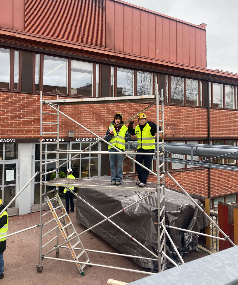 Students watching while standing on scaffolding