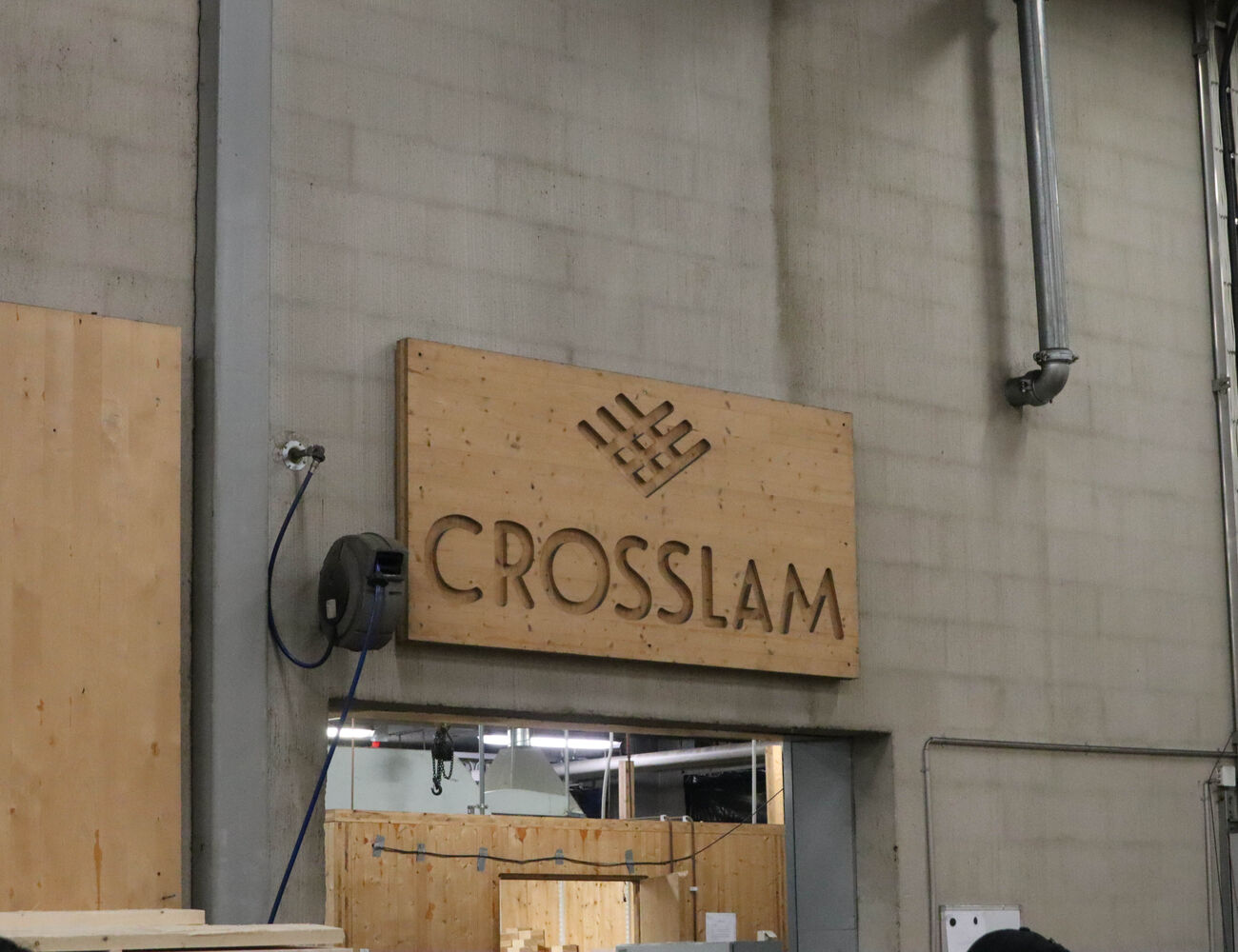 A CNC cut wooden panel showing the Crosslam logo in their factory