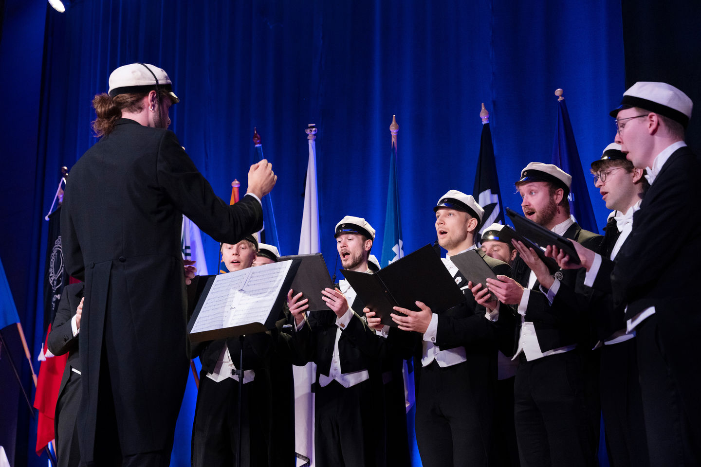 A male choir singing with tuxedos on 