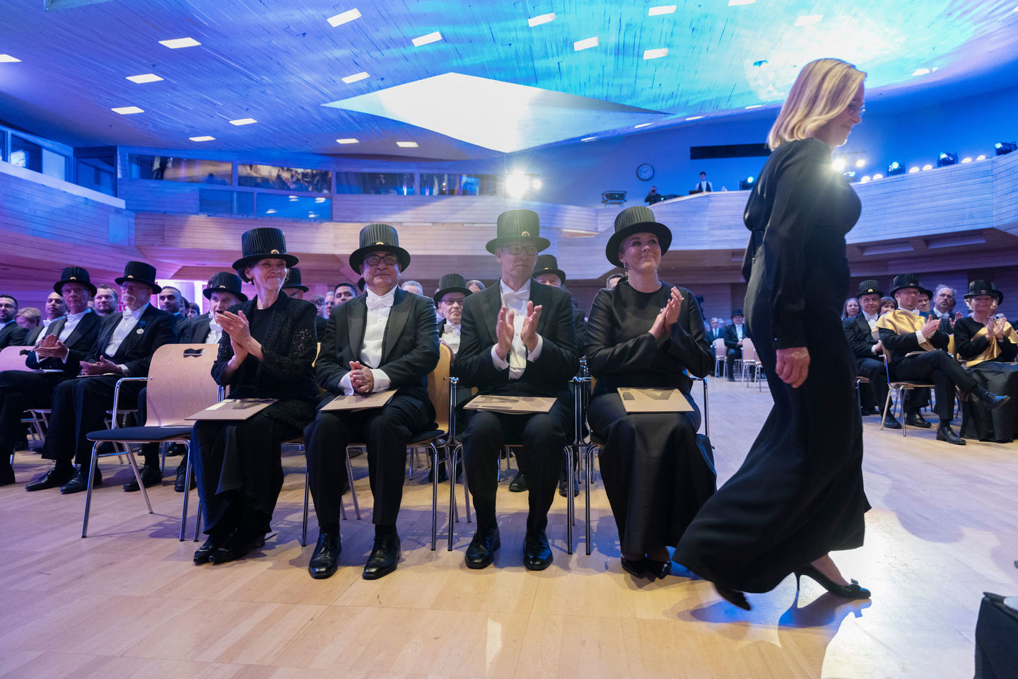 Dressed up people sitting a festive hall