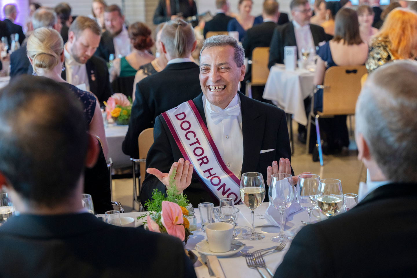 A man smiling on a formal dinner