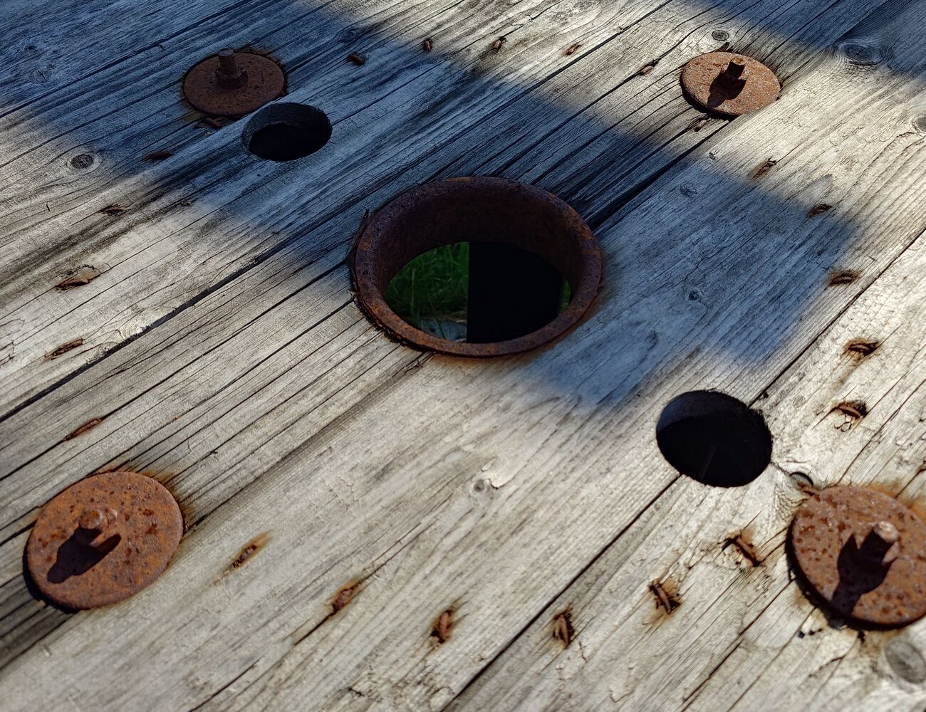 Rusty metal on grey wood