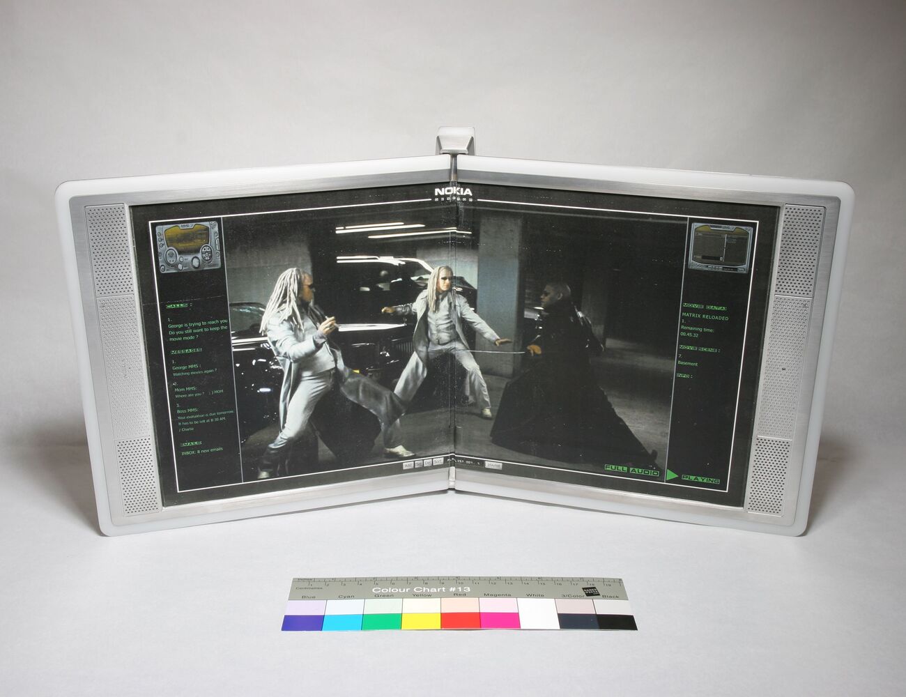 A dual-screen Nokia device displaying a movie scene with two silver-haired characters fighting in a garage.