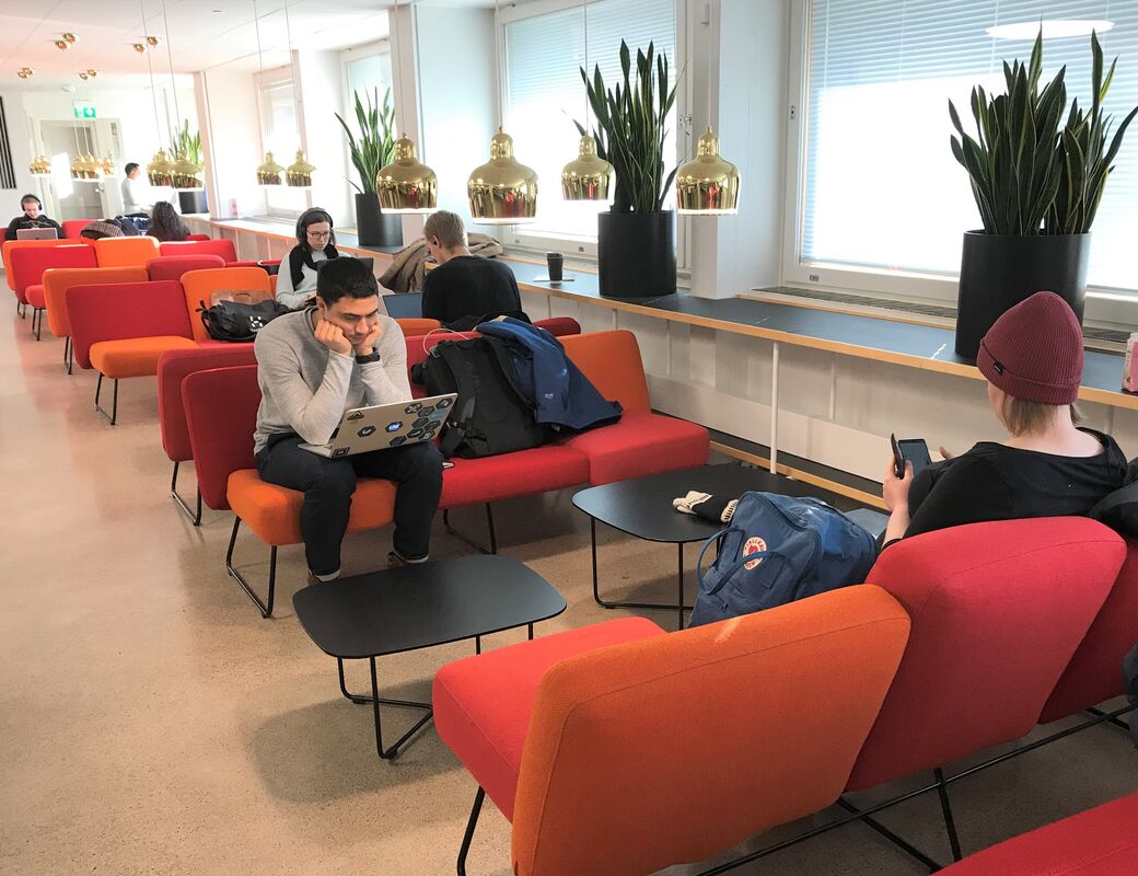 Valokuva Oppimiskeskuksen 1. kerroksen kahvilasta, jossa on asiakkaita.