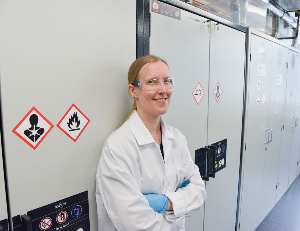 Taina in lab gear in the laboratoy smiling