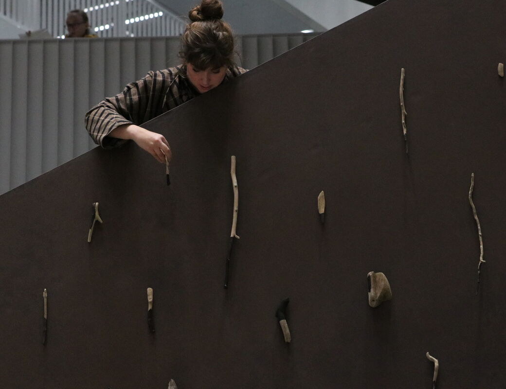 A student hangs her work from one of the stairwells in the Vare building at Aalto University