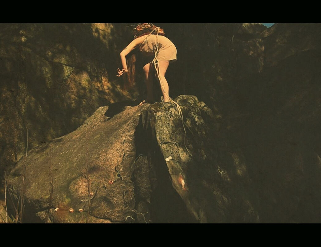REPULSIVE BUT DELICIOUS. Tereza Holubová. Still. A figure crouches over at the top of a rock face.