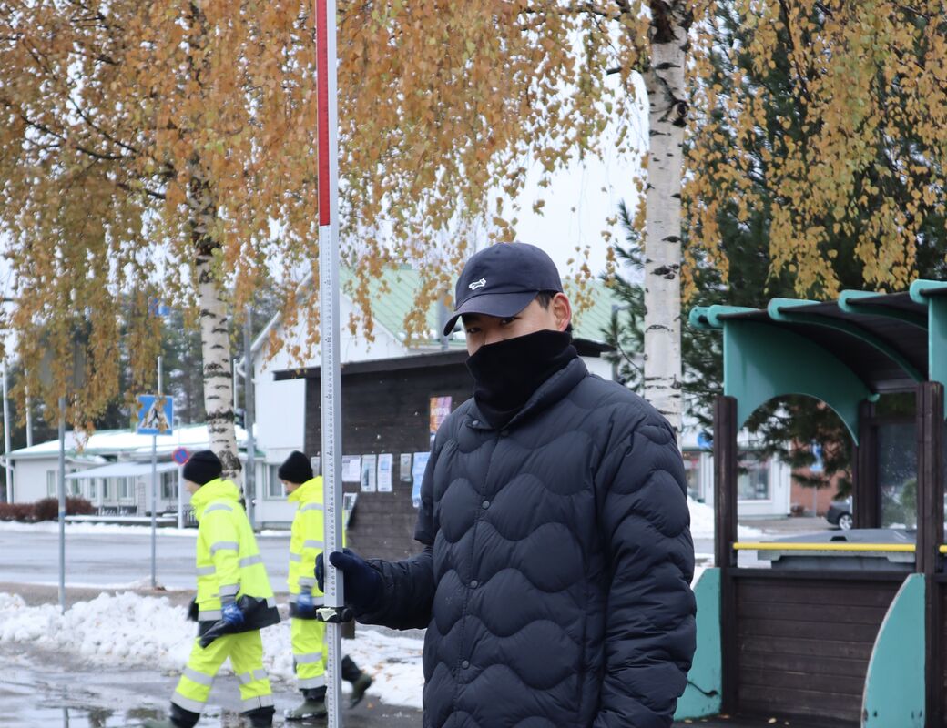 A Japanese member is standing with long ruler