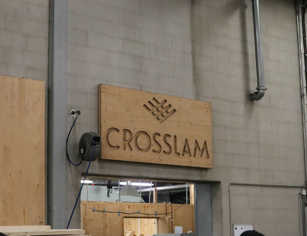 A CNC cut wooden panel showing the Crosslam logo in their factory