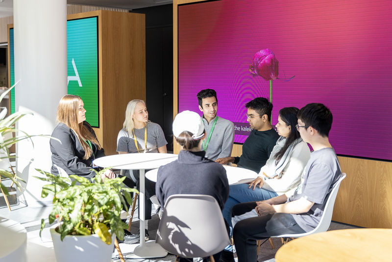 A group of people sitting around a table and talking to each other.