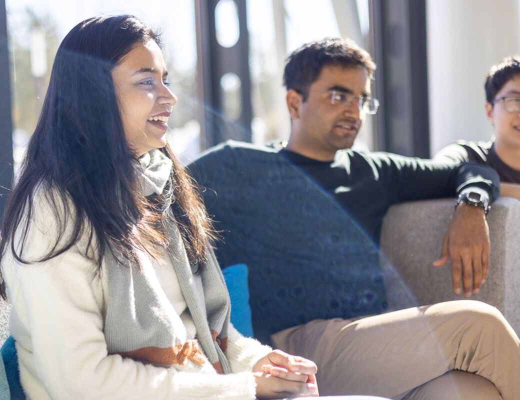 Three students participating in the Aalto International Talent Program sitting on a sofa while visiting their mentor company.