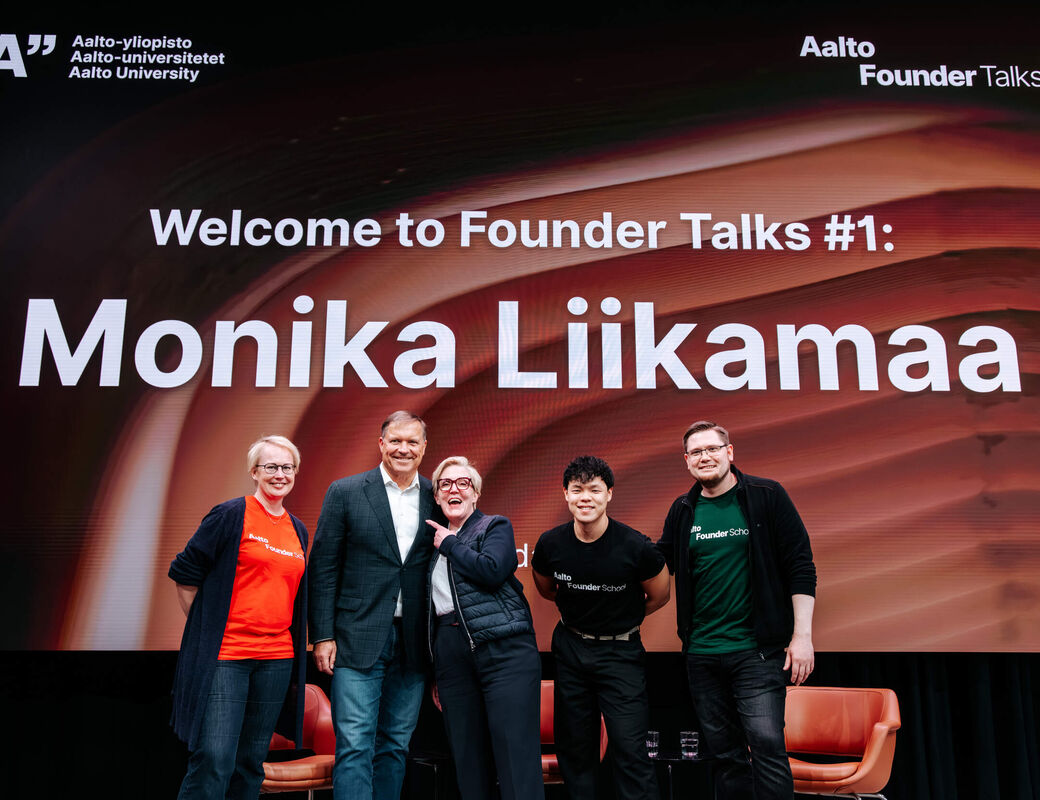Fem personer poserar på scen framför en Aalto Founder Talks‑skärm med texten Monika Liikamaa.