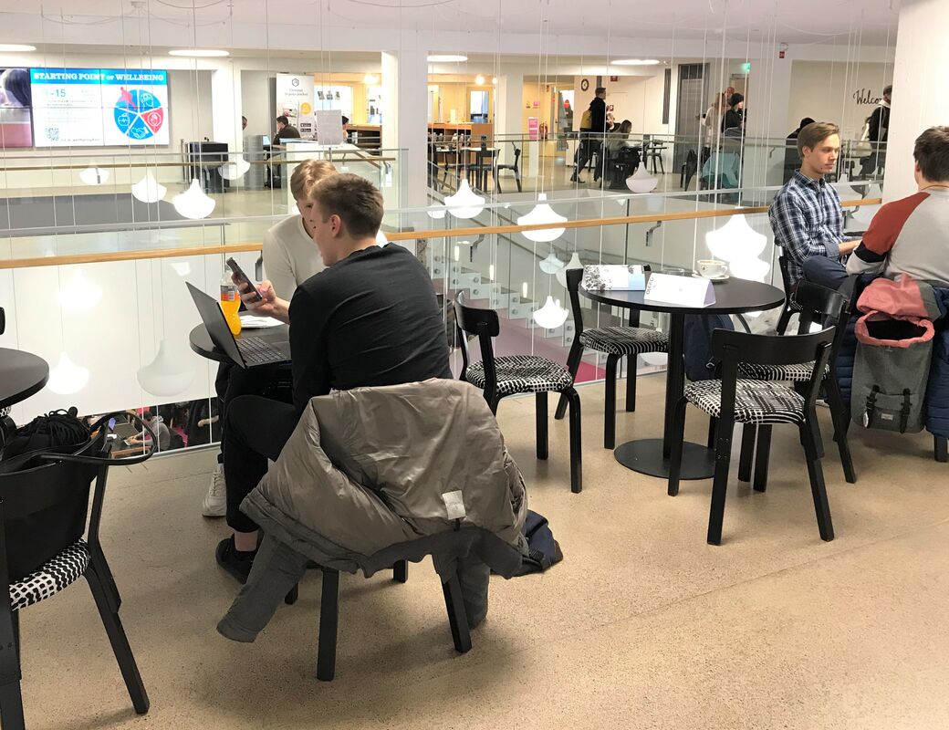 Valokuva Oppimiskeskuksen 1. kerroksen kahvilasta, jossa on asiakkaita.