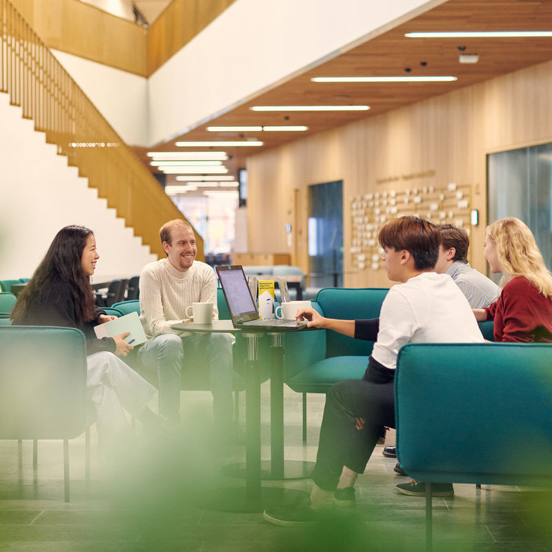 Opiskelijoita istumassa Kauppakorkeakoulun pohjakerroksessa