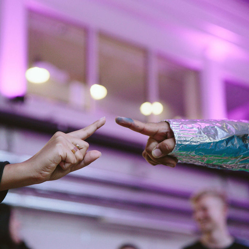 Kahden erilaisen ihmisen sormenpäät melkein koskettavat toisiaan.