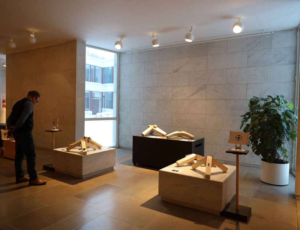 Wooden joint tripods standing on marble plinths in the exhibition space