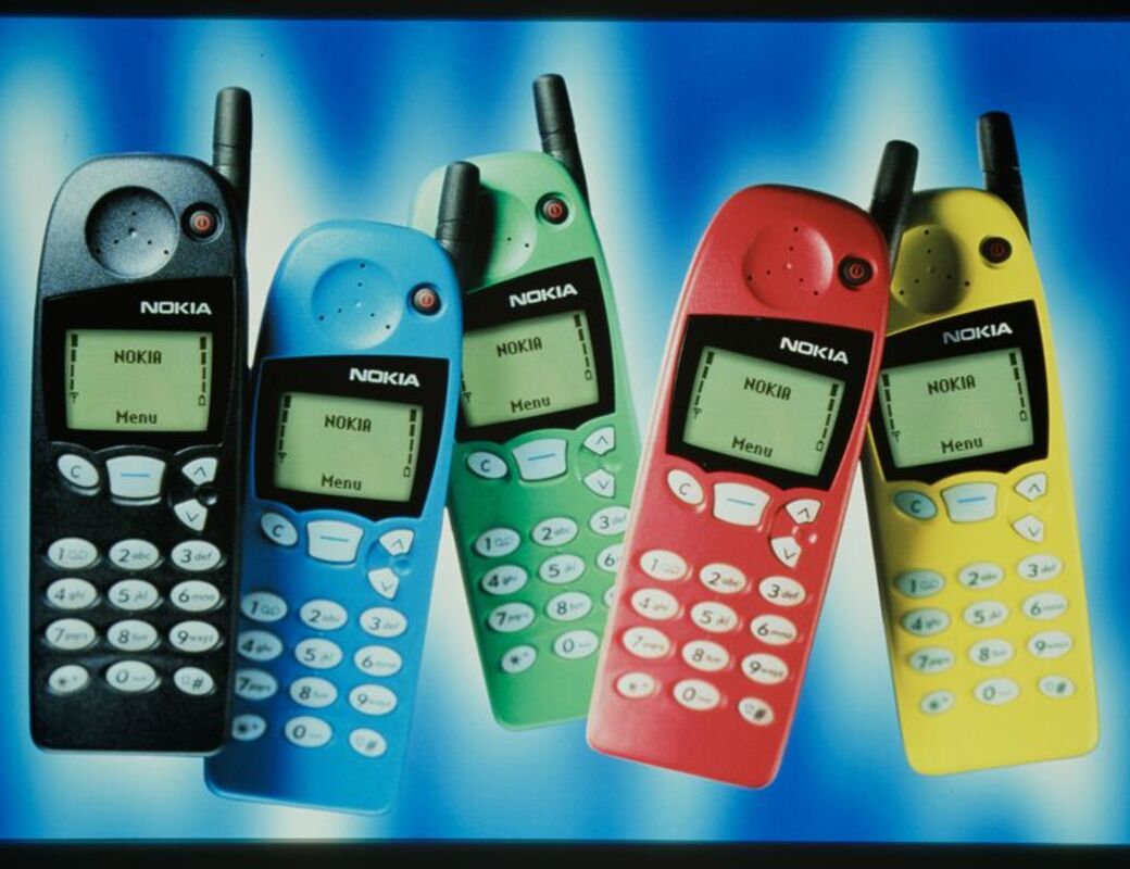 Five Nokia mobile phones in black, blue, green, red, and yellow are displayed against a blue and white background.