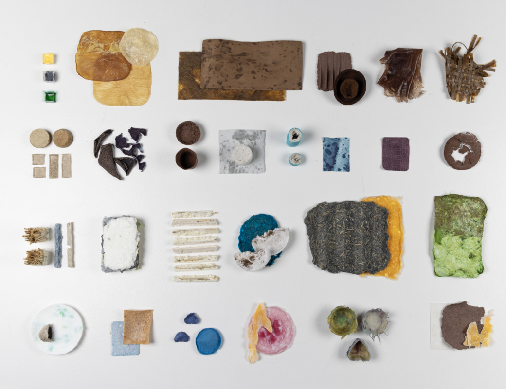 Assorted flat and textured material samples in varied shapes and colours arranged in a grid on a white surface