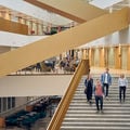 Four students descending stairs in the School of Economics building. Photo taken by Unto Rautio.