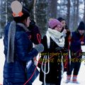 Artists from the peripheries in parallax research group take part in a performance: they hold a red string between them. They stand in a snowy forest.