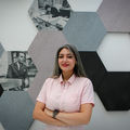 Sanaz Zarabi in the middle of frame with hexagonal artwork behind her.