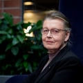 Professori Kaisa Nyberg istuu isolla tuolilla Aalto-yliopiston tietotekniikan talossa, tasutalla on viherkasveja
